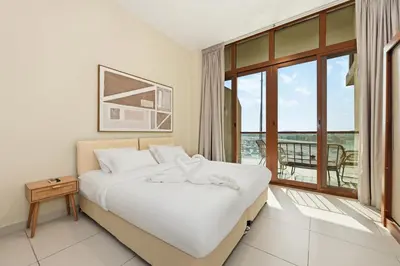 a hotel room with a bed and a balcony at Amazing Views of Palm & Dubai Eye Stylish Studio in Dubai