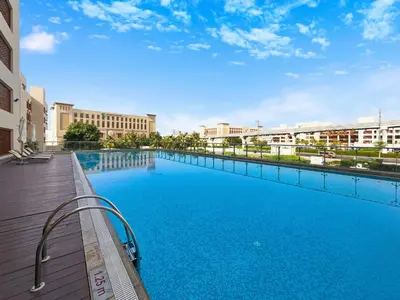 a large swimming pool next to a building at Amazing Views of Palm & Dubai Eye Stylish Studio in Dubai