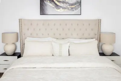 a bedroom with a large white bed with two lamps at Stylish 2-Bedroom Apartment with Marina View JBR in Dubai