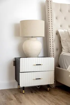 a lamp on a night stand next to a bed at Stylish 2-Bedroom Apartment with Marina View JBR in Dubai