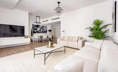 a white living room with a white couch and a table at Stylish 2-Bedroom Apartment with Marina View JBR in Dubai