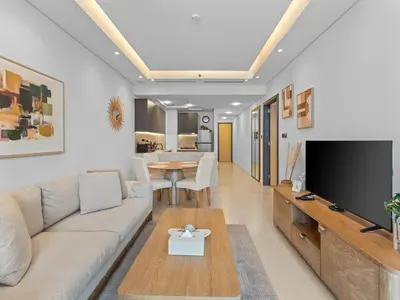 a living room with a couch and a tv at Convenient City Apartment Near Metro & Downtown in Dubai