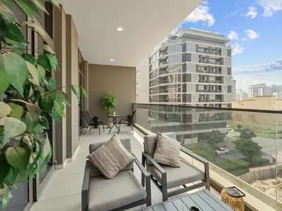 a balcony with two chairs and a view of a building at Convenient City Apartment Near Metro & Downtown in Dubai