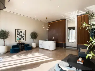 a lobby with blue chairs and a reception desk at Palace Beachfront Dubai Harbour in Dubai