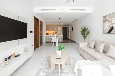 a white living room with a couch and a table at Modern Stay at The Crest Tower Near Meydan with Pool and Sauna in Dubai