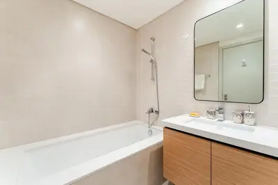 a bathroom with a tub and a sink and a mirror at Creek crescent in Dubai