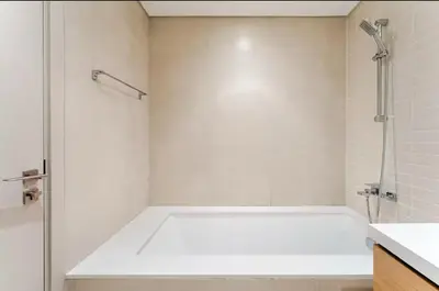 a white bathroom with a shower and a tub at Creek crescent in Dubai