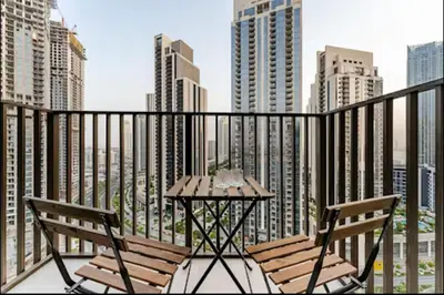 two chairs and a table on a balcony with a city skyline at Creek crescent in Dubai