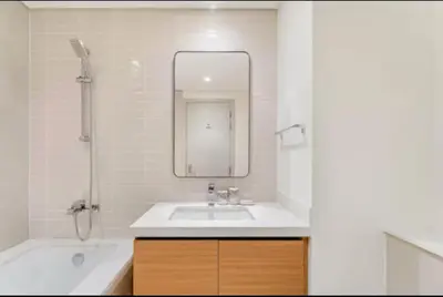 a bathroom with a sink and a tub and a mirror at Creek crescent in Dubai