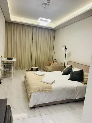 a bedroom with a large bed and a couch at Modern Studio Retreat in Al Barsha South Dubai in Dubai