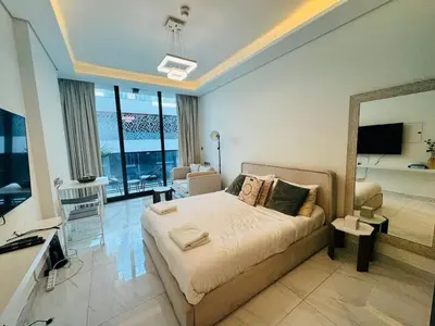 a bedroom with a bed and a living room at Modern Studio Retreat in Al Barsha South Dubai in Dubai
