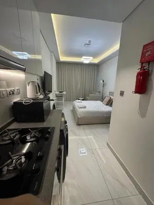 a kitchen with a stove and a room with a bed at Modern Studio Retreat in Al Barsha South Dubai in Dubai