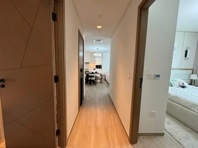 a hallway leading to a bedroom with a bed and a table at Luxury two beds apartment in Dubai