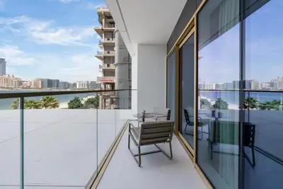 an apartment balcony with a view of the city at Beachfront Luxe 1BR Grand Bleu with Private Beach & Sea View in Dubai