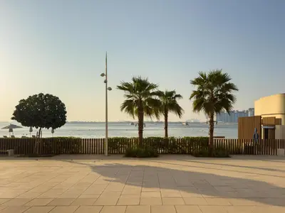 a row of palm trees next to the ocean at Beachfront Luxe 1BR Grand Bleu with Private Beach & Sea View in Dubai