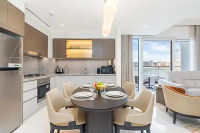 a kitchen and dining room with a table and chairs at Beachfront Luxe 1BR Grand Bleu with Private Beach & Sea View in Dubai