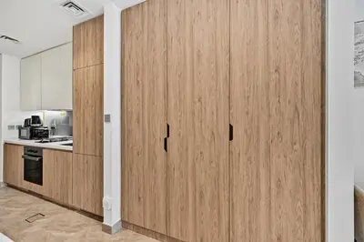 a kitchen with wooden cupboards in a room at Deluxe Studio for 2 in Peninsula One, Business Bay in Dubai