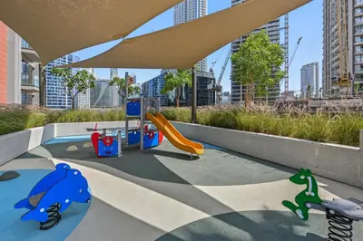 a playground with a slide and play equipment in a city at Deluxe Studio for 2 in Peninsula One, Business Bay in Dubai