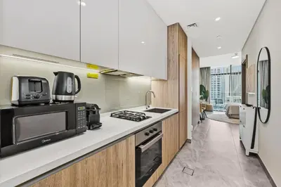 a kitchen with a microwave and a stove at Deluxe Studio for 2 in Peninsula One, Business Bay in Dubai