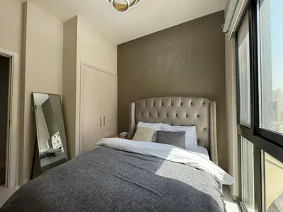 a bedroom with a large bed with a large window at Luxury Smart Home Villa Damac Hills 2 3BR Ensuite in Dubai