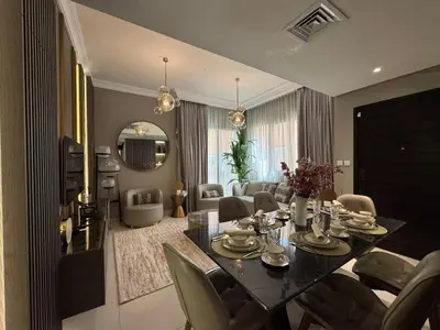 a dining room with a table and a living room at Luxury Smart Home Villa Damac Hills 2 3BR Ensuite in Dubai