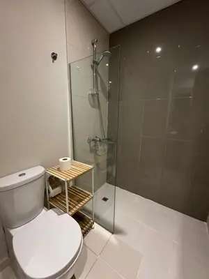 a bathroom with a toilet and a glass shower at Luxury Smart Home Villa Damac Hills 2 3BR Ensuite in Dubai
