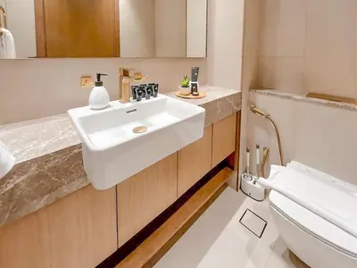 a bathroom with a white sink and a toilet at Warm Modern 2BR Retreat with Private Pool in JVC! in Dubai
