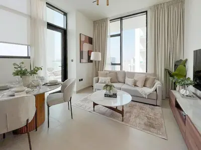 a living room with a couch and a table at Warm Modern 2BR Retreat with Private Pool in JVC! in Dubai
