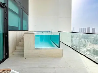 a living room with a large tv in a building at Warm Modern 2BR Retreat with Private Pool in JVC! in Dubai