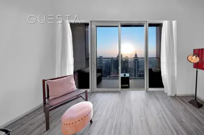 a living room with a chair and a window at Grande Tower by Emaar, Downtown, Burj Khalifa in Dubai
