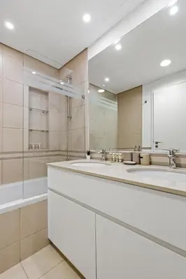 a bathroom with two sinks and a large mirror at Town Square Zahra 2B - 2 Bedroom Apartment - Allsopp & Allsopp in Dubai