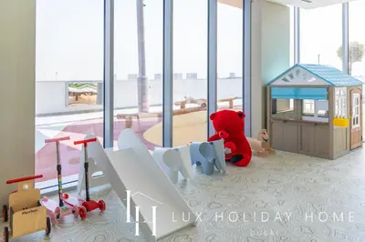 a red teddy bear sitting next to a toy house at LUX The Burj Khalifa Lagoon View Suite 4 in Dubai