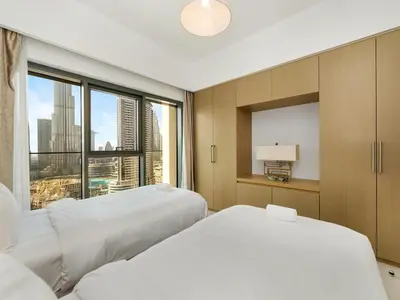 a hotel room with two beds and a large window at ABI Holiday Homes - Burj Khalifa and Fountain view Downtown in Dubai