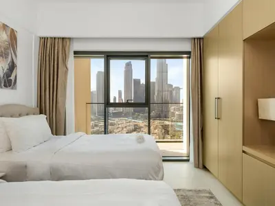 a hotel room with two beds and a large window at ABI Holiday Homes - Burj Khalifa and Fountain view Downtown in Dubai