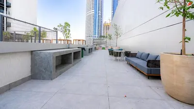 a balcony with a couch and tables on a building at The Nobles Tower High Floor with Elegant City View in Dubai