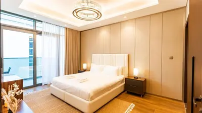 a bedroom with a white bed and a large window at The Nobles Tower High Floor with Elegant City View in Dubai