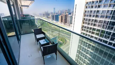 a balcony with two chairs and a table on a building at The Nobles Tower High Floor with Elegant City View in Dubai