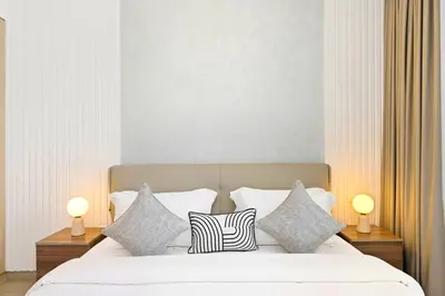 a bedroom with a bed with pillows and two lamps at Lamtara in Dubai