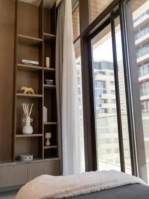 a bedroom with a large glass window and a bed at Brand New 1BR Apartment in JVC in Dubai