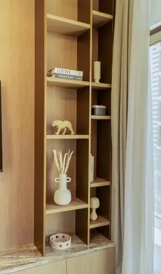 a book shelf with a vase in a room at Brand New 1BR Apartment in JVC in Dubai