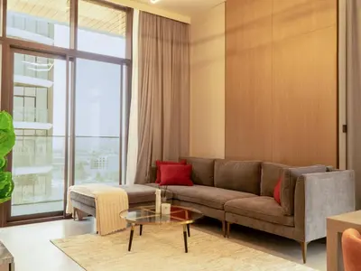 a living room with a couch and a table at Brand New 1BR Apartment in JVC in Dubai
