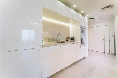 a white kitchen with white cabinets and appliances at Panoramic Sea and Canal Views from High-Floor 2BR, Steps from Tram and Marina Beach, Shams 2, JBR by Dekuxe Holiday Homes in Dubai