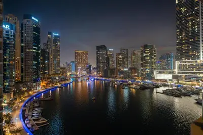 a city skyline at night with a river and buildings at GuestReady - Cozy Studio | Pool & Gym | Canal view in Dubai