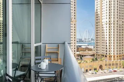 a table and chairs on a balcony with a view of a city at GuestReady - Cozy Studio | Pool & Gym | Canal view in Dubai