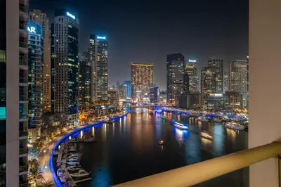 a city skyline at night with a river and buildings at GuestReady - Cozy Studio | Pool & Gym | Canal view in Dubai