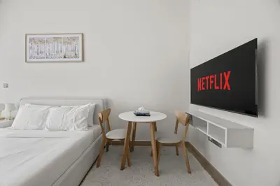 a bedroom with a bed and a table and a tv at Elite Escape - Getaway in Azizi Riviera 29 in Dubai