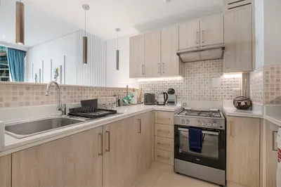 a kitchen with a sink and a stove top oven at Restay Homes at Seven Palm Hotel & Apartments - Pool and Beach Access included in Dubai