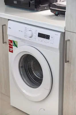 a white washing machine sitting under a counter at Restay Homes at Seven Palm Hotel & Apartments - Pool and Beach Access included in Dubai