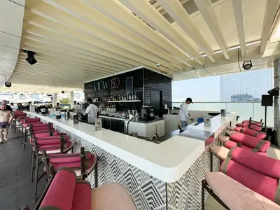 a restaurant with a bar with red chairs at Restay Homes at Seven Palm Hotel & Apartments - Pool and Beach Access included in Dubai