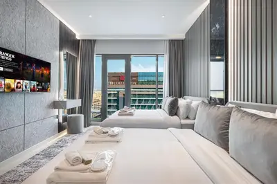 a living room with a white couch and a large window at Restay Homes at Seven Palm Hotel & Apartments - Pool and Beach Access included in Dubai